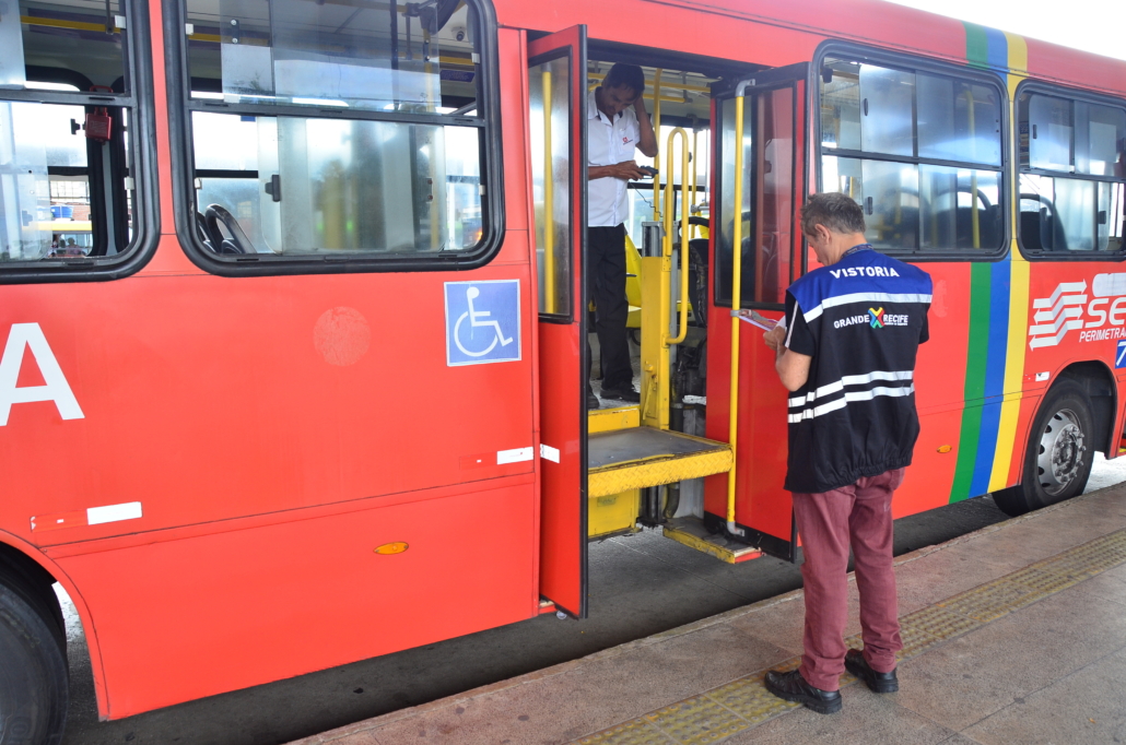 Técnicos de fiscalização realizando vistoria em ônibus