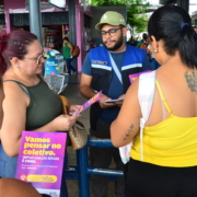 Homem entregando panfleto para três mulheres