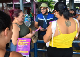 Homem entregando panfleto para três mulheres
