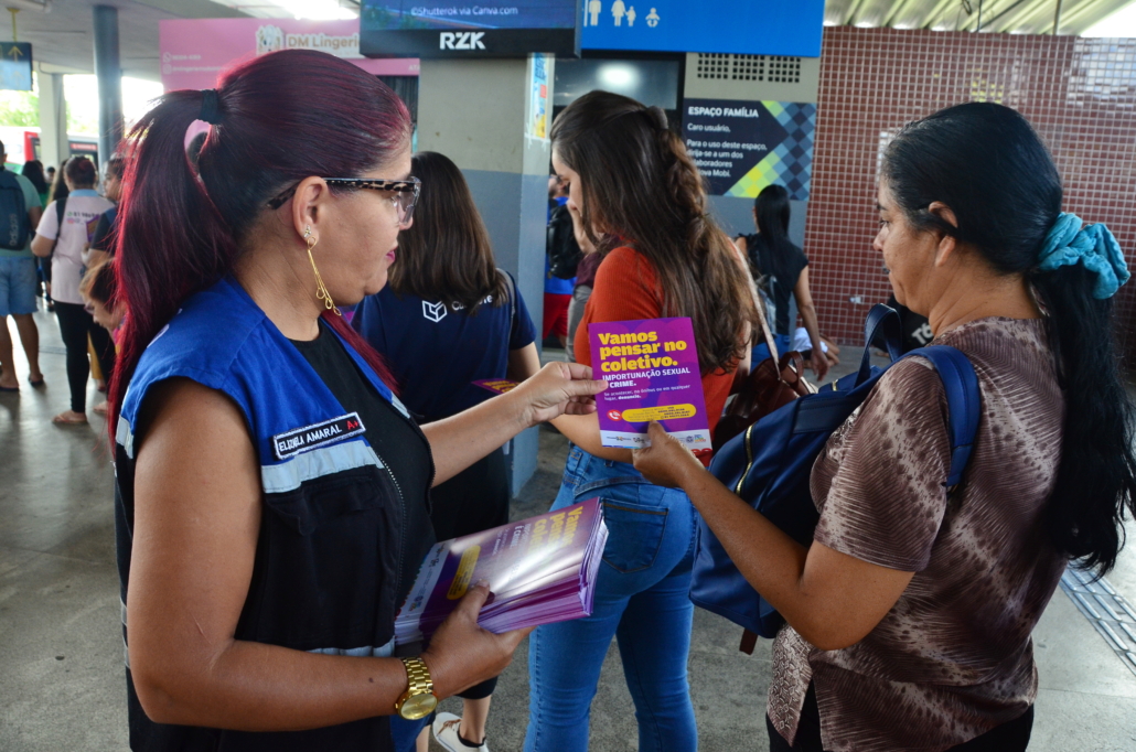 Mulher entregando panfleto para outra mulher