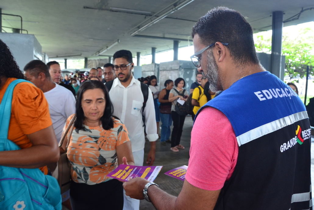 Homem entregando panfleto para mulher