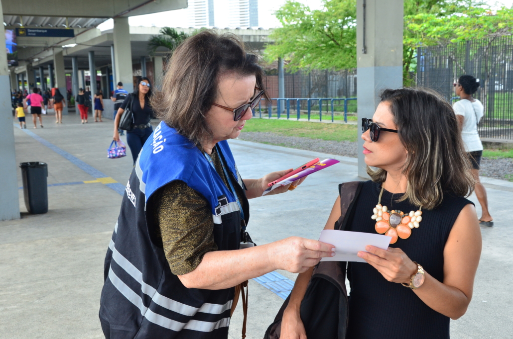 Mulher entregando panfleto para mulher