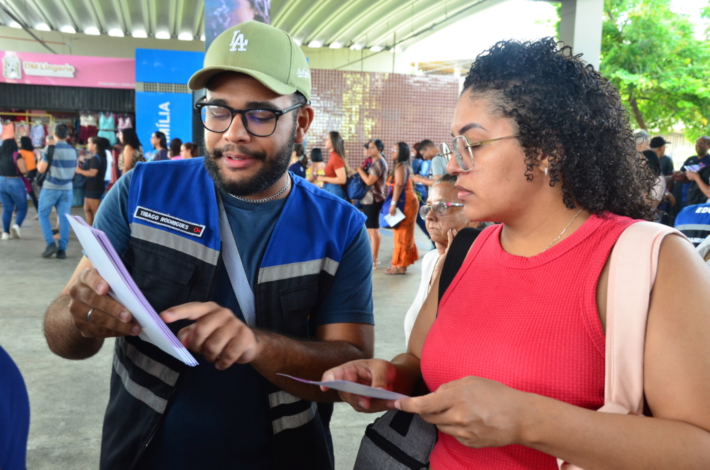 Homem explicando panfleto para mulher
