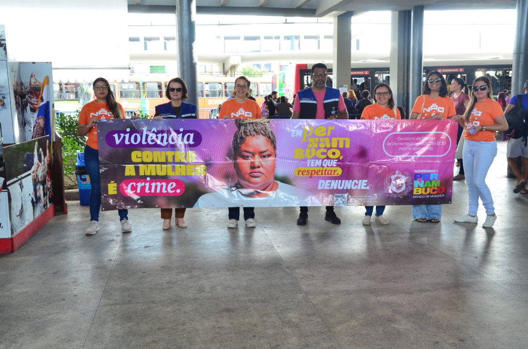 Equipe de educação e fiscalização do Consórcio de Transporte Metropolitano e equipe da Secretaria da Mulher pousando com faixa 