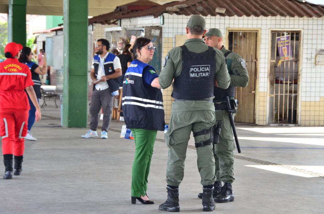 Mulher conversando com dois policiais masculinos