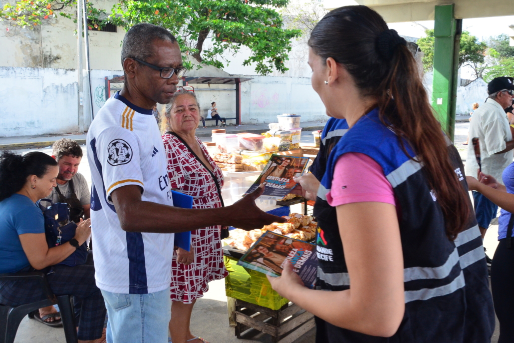 Mulher entregando panfleto para um homem