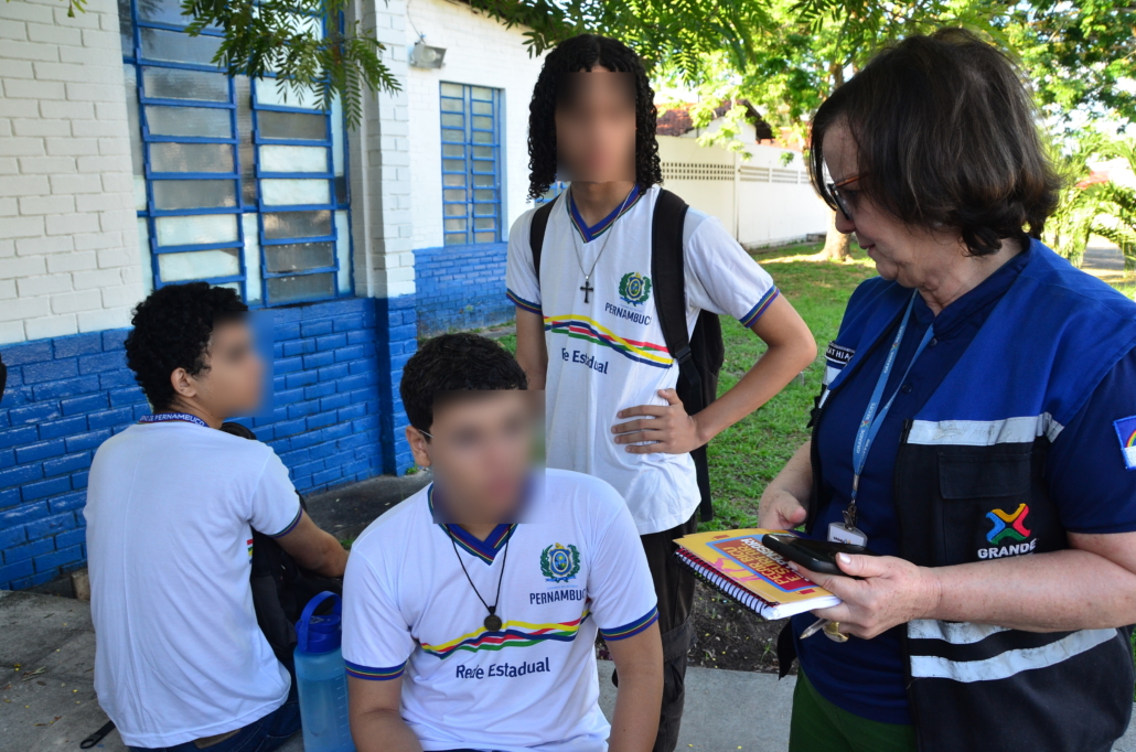 Mulher conversando com três meninos. 