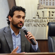 Perfil do Diretor-Presidente do Consórcio de Transporte Metropolitano, Matheus Freitas, que está falando no microfone.